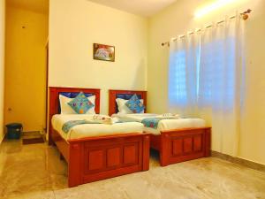 two twin beds in a room with a window at Hotel Propel Inn in Dobbspet