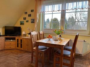 een eetkamer met een tafel, stoelen en een televisie bij Ferienwohnung Dorle in Benneckenstein