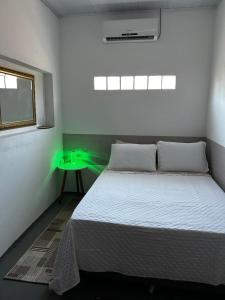 a bedroom with a bed with a green light on it at Espaço para Hermanos in São Gabriel
