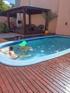 two people are swimming in a swimming pool at Espaço para Hermanos in São Gabriel