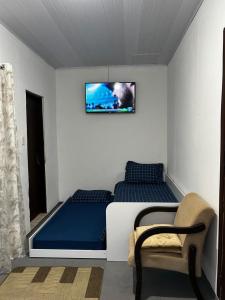 a bedroom with a bed and a tv on the wall at Espaço para Hermanos in São Gabriel