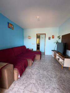 een woonkamer met een bank en een tv bij Casa em Itapoá - Barra do Saí in Itapoa