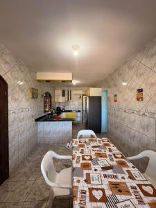 een eetkamer met een tafel en stoelen en een keuken bij Casa em Itapoá - Barra do Saí in Itapoa