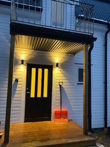 uma casa com uma porta preta e um banquinho laranja em High Coast Stay em Ramvik