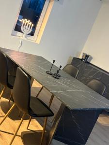 uma mesa preta com cadeiras ao redor e copos em cima dela em High Coast Stay em Ramvik