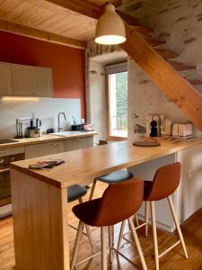 een keuken met een grote houten tafel en stoelen bij Gîte Le COCON au Clarou in Valleraugue
