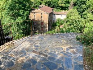 een smeedijzeren hek met een stenen terras bij Gîte Le COCON au Clarou in Valleraugue