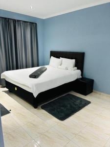 a bedroom with a large bed with a black headboard at RT Guest House in Walvis Bay