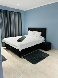 a bedroom with a large bed with a black headboard at RT Guest House in Walvis Bay