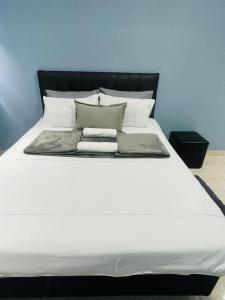 a large bed with white sheets and pillows at RT Guest House in Walvis Bay +22 photos