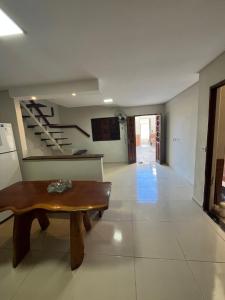 un soggiorno con un tavolo e una scala di Residência 02 - SIM! ACOMODAMOS 08 PESSOAS a Japaratinga