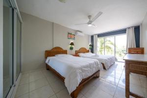 a bedroom with two beds and a large window at Hotel el kaoba in Cabarete
