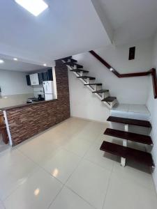 un soggiorno con scala e cucina di Residência 02 - SIM! ACOMODAMOS 08 PESSOAS a Japaratinga