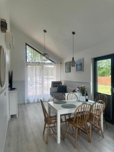 a dining room and living room with a table and chairs at Lakeview Houses in Gil Mały