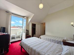 een hotelkamer met twee bedden en een balkon bij Mirasol Guesthouse in Funchal
