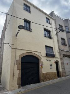 un grande edificio con una porta del garage di fronte di Cal Nina a Espluga de Francolí