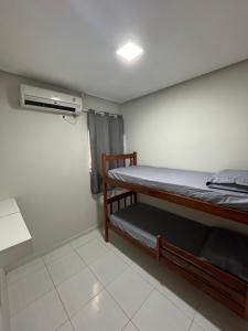 una piccola stanza con due letti a castello di Residência 02 - SIM! ACOMODAMOS 08 PESSOAS a Japaratinga