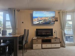 a living room with a table and a tv on the wall at The Suite in Tosside