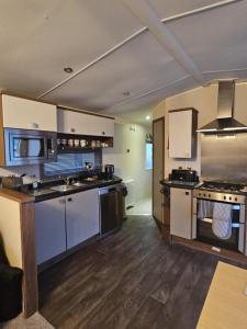 a large kitchen with stainless steel appliances and wooden floors at The Suite in Tosside