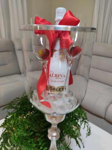 a wine glass with a bottle of wine and red heels at Albina apartman in Eger