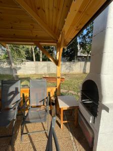 eine Terrasse mit Tisch, Stühlen und einem Ofen in der Unterkunft Heliolit in Dudince + 15 Fotos