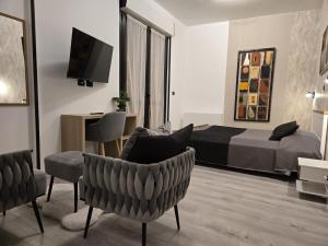 a bedroom with a bed and a couch and a chair at Hotel Cristallo in Novara