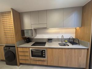 Studio moderno no Centro de Floripa CMA0101 في فلوريانوبوليس: مطبخ مع حوض وميكروويف