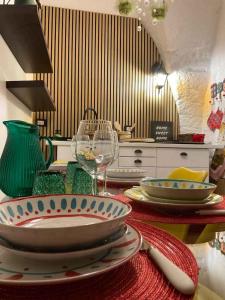Una cocina con una mesa con platos y copas de vino. en Ca' Teatro Vecchio, en Manfredonia