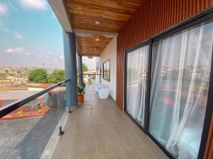 a balcony with large windows and a view of the city at EK'sPEAK in Kumasi