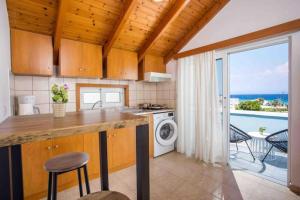 una cucina con lavatrice e asciugatrice e un balcone di MEGAT SEAVIEW AND SEASIDE APARTMENTs a Ialyssos