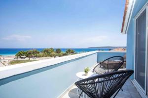 un balcone con due sedie e vista sull'oceano di MEGAT SEAVIEW AND SEASIDE APARTMENTs a Ialyssos