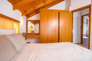 una camera da letto con un letto grande e un armadio in legno di MEGAT SEAVIEW AND SEASIDE APARTMENTs a Ialyssos