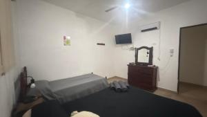 ein Schlafzimmer mit einem Bett, einer Kommode und einem Fernseher in der Unterkunft El descanso in El Rodeo
