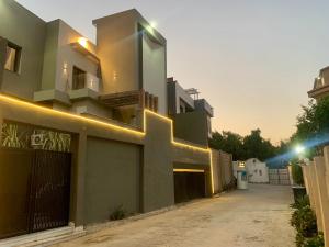 una casa con luci sui lati di For families only a Qaryat ash Shamālī