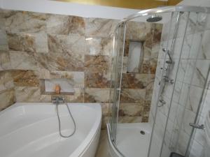 ein Badezimmer mit weißer Badewanne und Dusche in der Unterkunft Malownicze Owieczki  + 36 Fotos