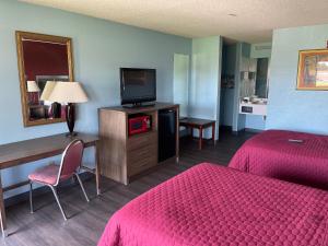 a hotel room with two beds and a flat screen tv at Mayfair Inn in Williamston