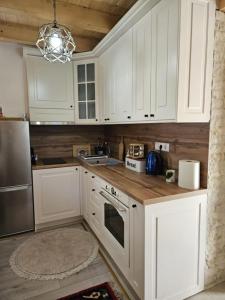 een keuken met witte kasten en roestvrijstalen apparaten bij Duric in Cazin +11 foto's