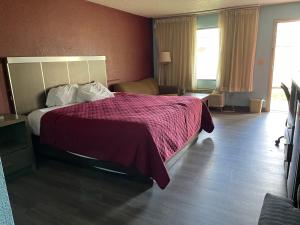 a hotel room with a bed with a purple blanket at Mayfair Inn in Williamston