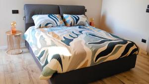 a bed with a colorful comforter in a bedroom at La Morra Apartments in La Morra