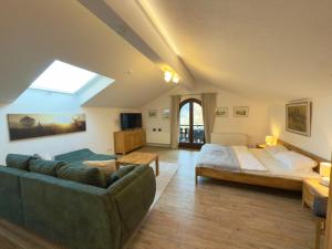 a living room with a couch and a bed at Gästehaus Florian in Grainau