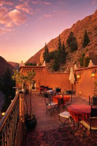 een patio met tafels en stoelen op een balkon bij Auberge La Fibule Du Dades in Aït Idaïr