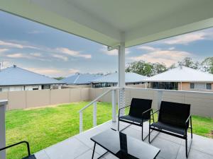 2 sedie su un portico con vista su un cortile di Hunter Valley Modern 4-Bedroom House a North Rothbury