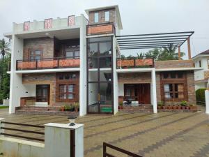 ein Haus mit einem großen Fenster und einem Balkon in der Unterkunft Riverbank Gardens in Mananthavady