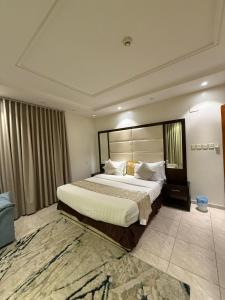 een slaapkamer met een groot bed in een kamer bij فيو المنسك للشقق المخدومه in Abha
