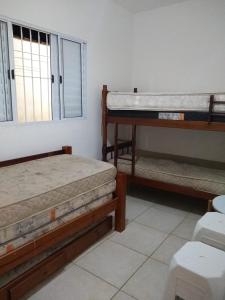 a room with two beds and a window at Linda Casa Mongagua COM 03 DORMS in Mongaguá