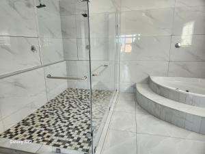 een witte badkamer met een douche en een bad bij Pado B & B in Gqeberha +22 foto's