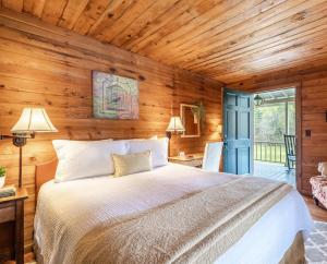 ein Schlafzimmer mit einem Bett und einer Holzwand in der Unterkunft Glen-Ella Springs Hotel & Restaurant in Clarkesville + 41 Fotos