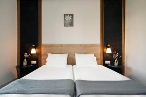 two beds in a bedroom with two lamps on the wall at Kokkinia Gardens in Kavos