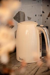 a white kettle sitting on top of a table at Kokkinia Gardens in Kavos