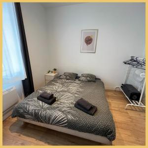 een slaapkamer met een bed met twee kussens erop bij Appartement St Genis Laval Hyper centre in Saint-Genis-Laval